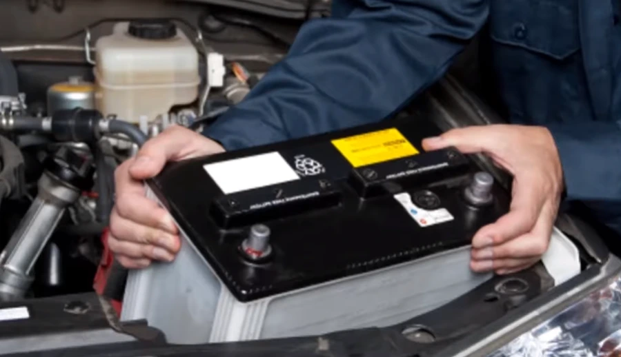 Technician installing a new car battery on site in Lubbock