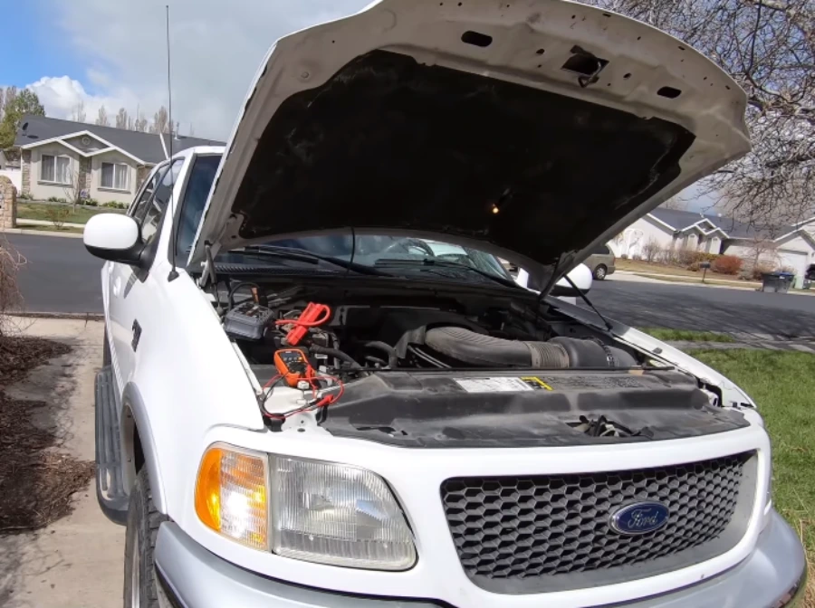 Tester leads clipped to a pickup battery during a driveway no-start check
