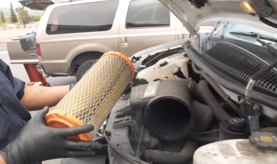 Mobile mechanic checking an engine air filter at a customer's home in Lubbock